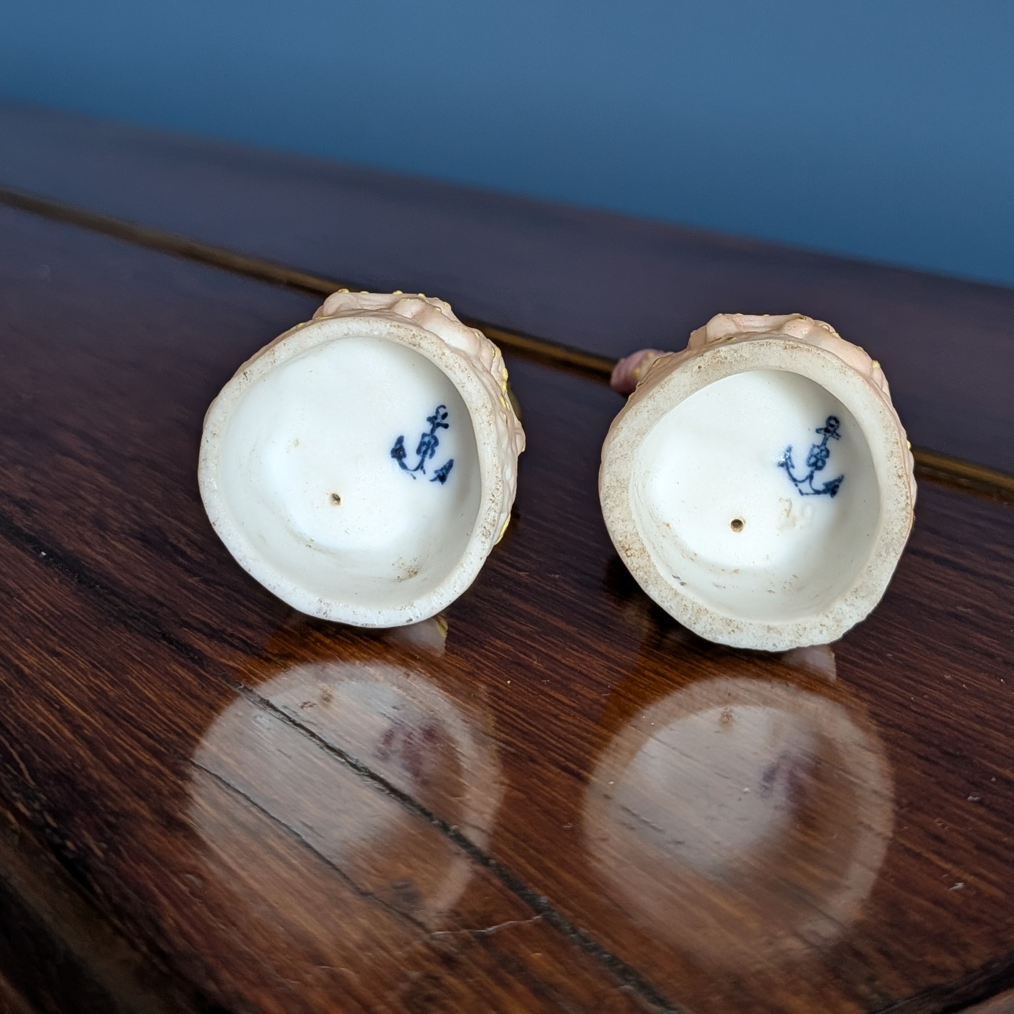 Undersides of both figurines showing blue anchor-shaped marks and base wear