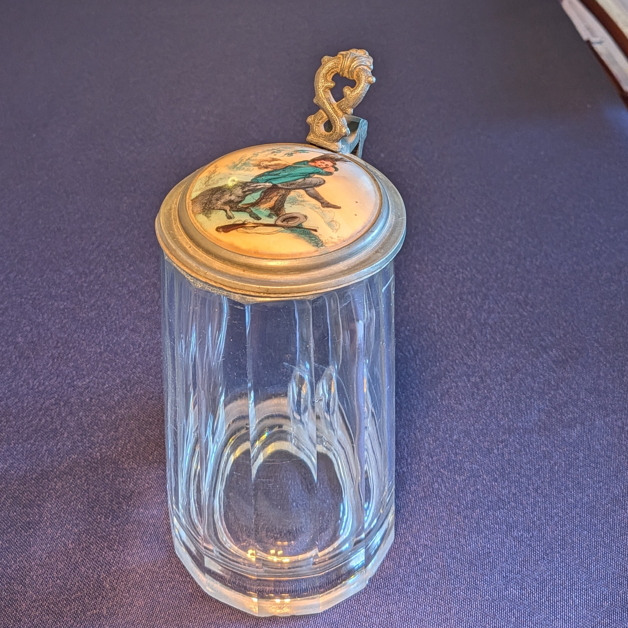 Front view of the glass beer tankard with its illustrated lid closed.