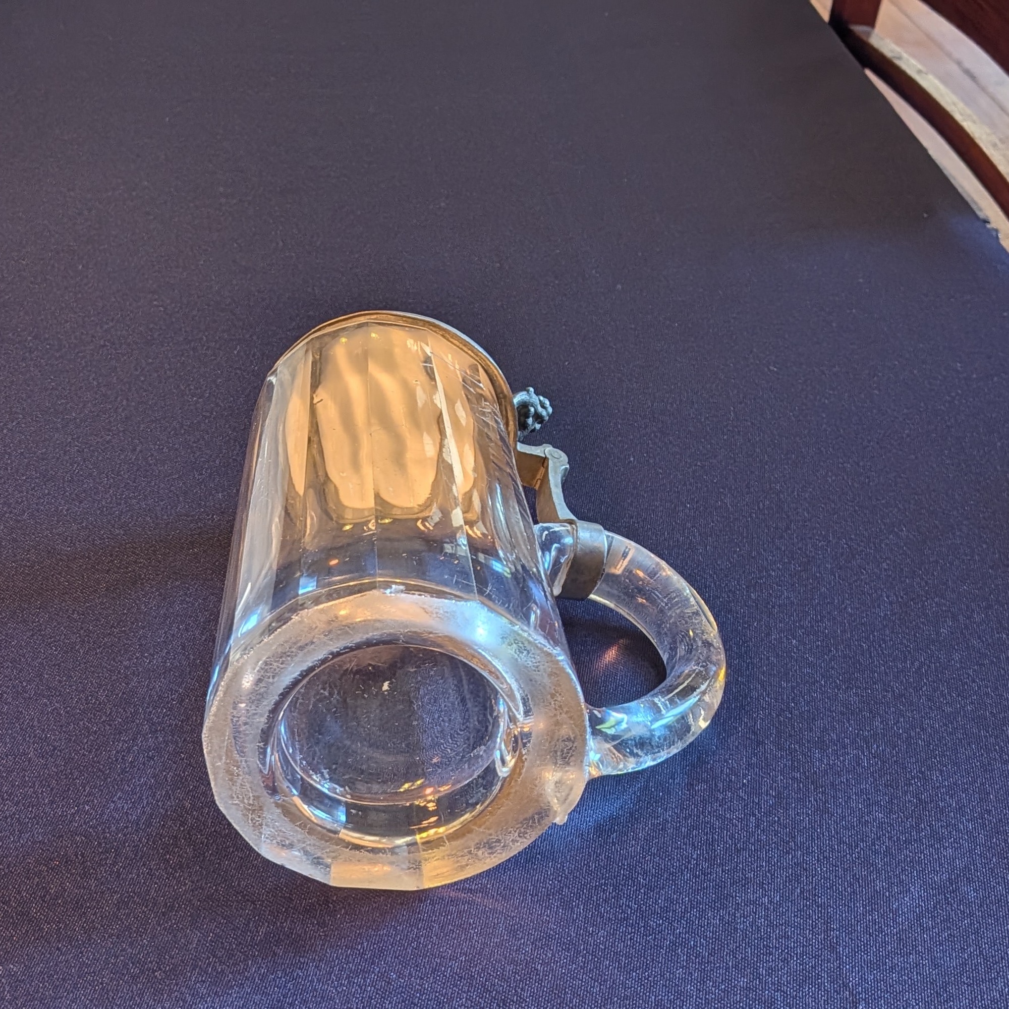 Underside of the glass tankard, showing scratches and wear around the base.