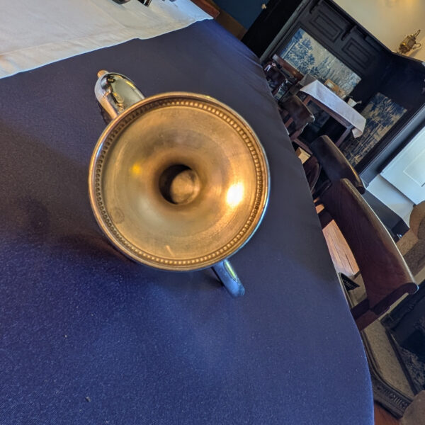 Underside of the shorter metal pot pedestal base, showing its circular foot and aged finish.