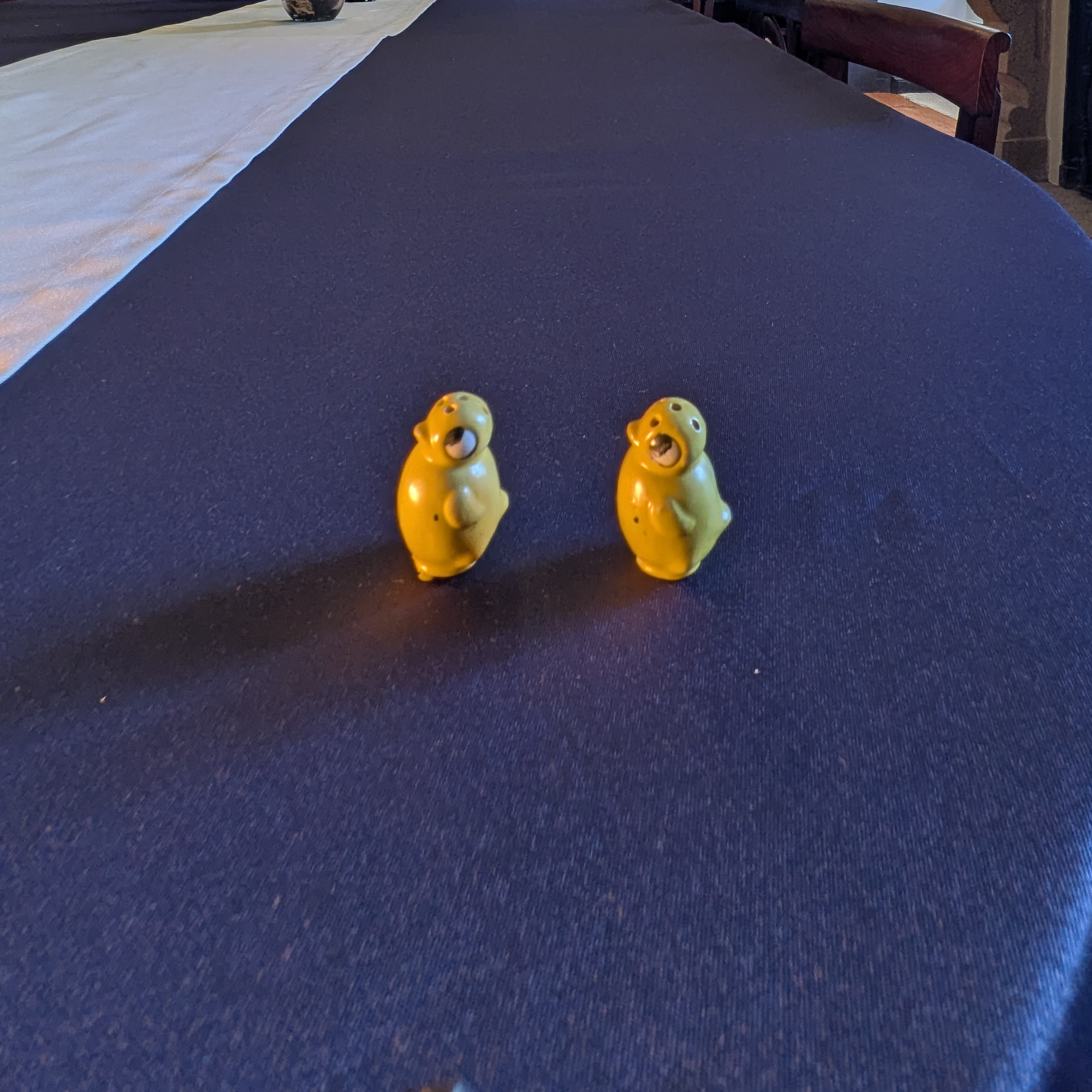 Miniature yellow chick salt and pepper shakers viewed from a three-quarter angle.