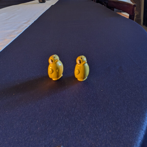 Side view of the two yellow chick shakers with raised wings.