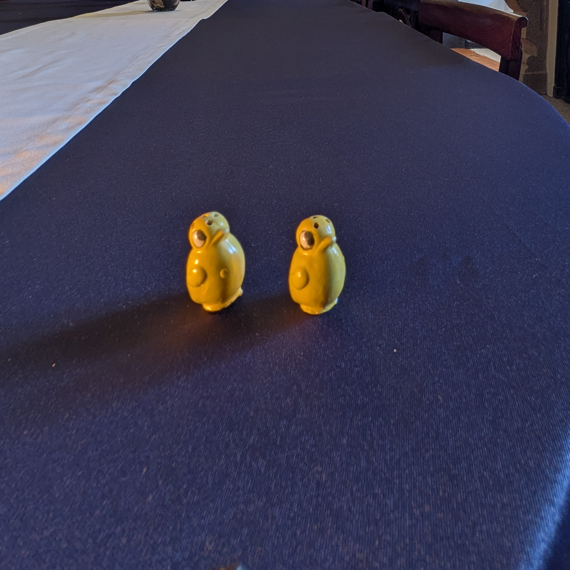 Side view of the two yellow chick shakers with raised wings.