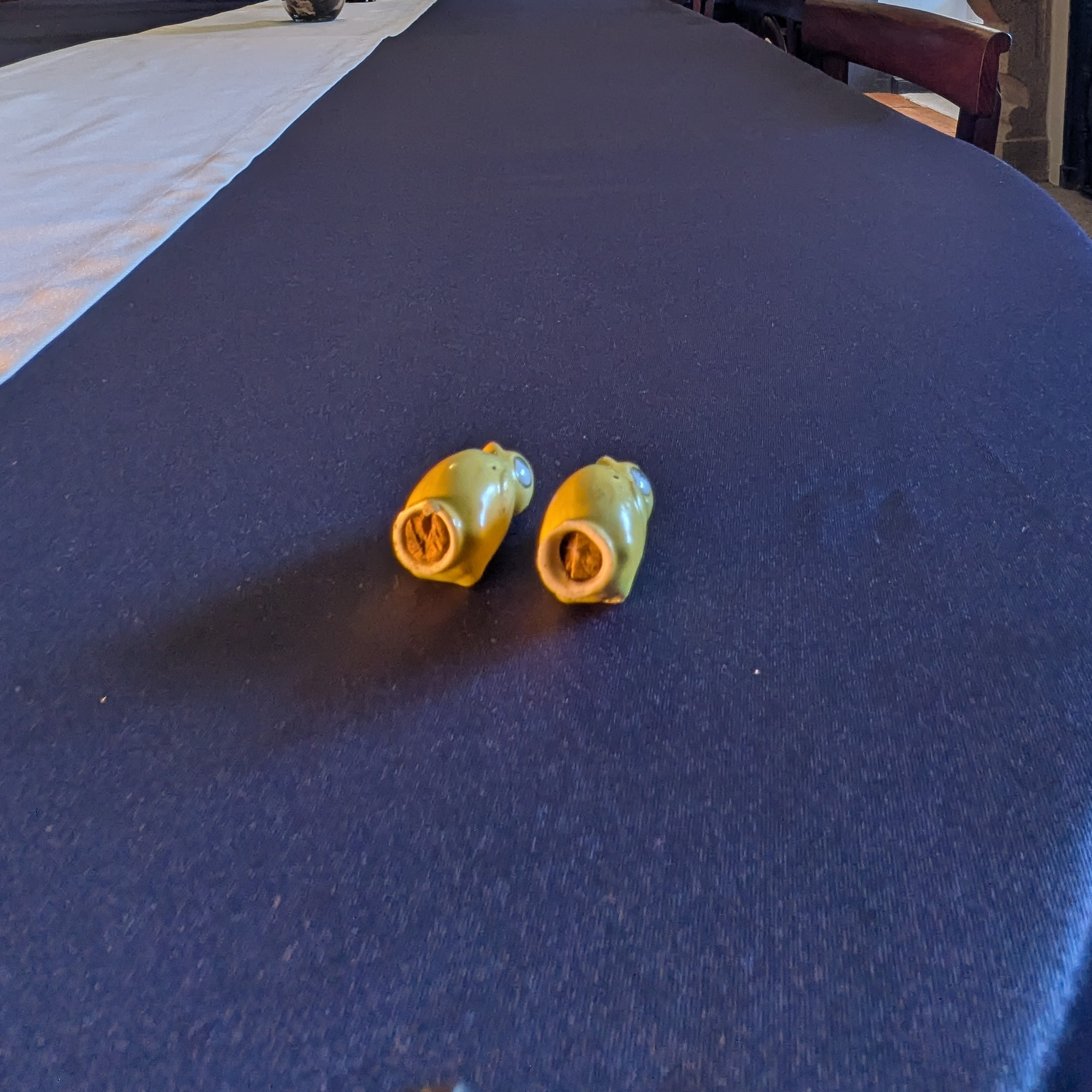 Underside view of the yellow chick shakers showing their circular base openings and brown material inside.
